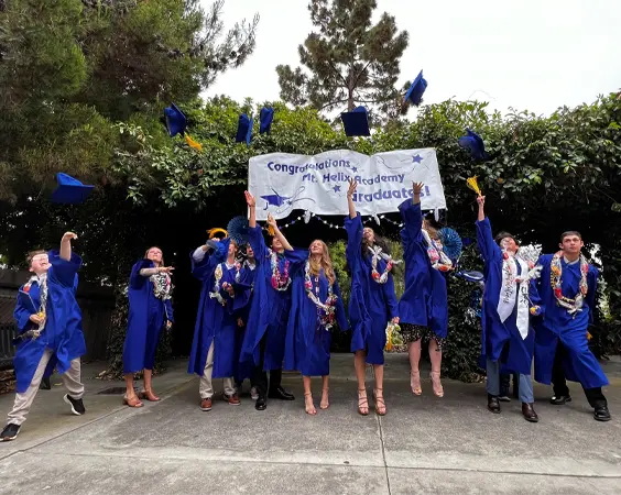 academics11 Students celebrate their graduation from Mt. Helix Academy by throwing their caps into the air.